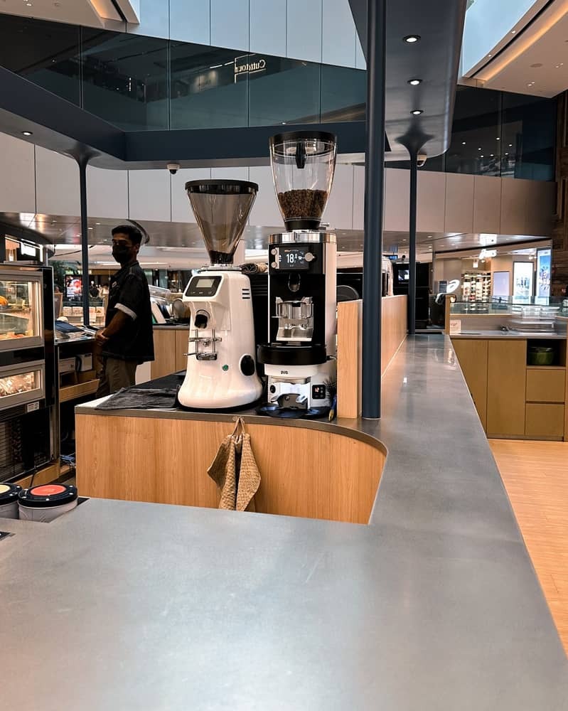 Overview of a sleek coffee station with an integrated Puqpress and grinder for efficient workflow.